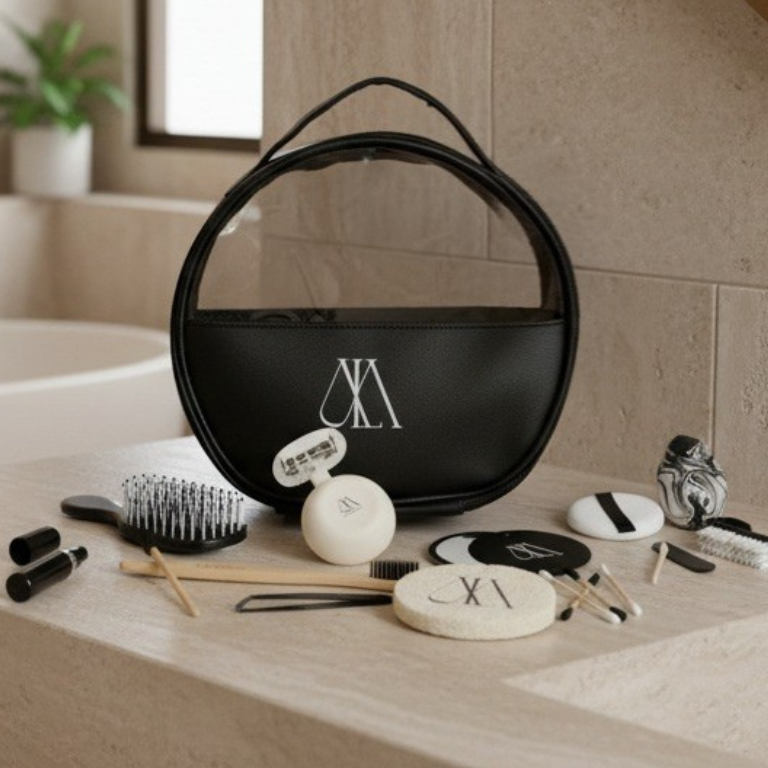 Black circular bag with a brand logo on a bathroom counter with grooming tools.