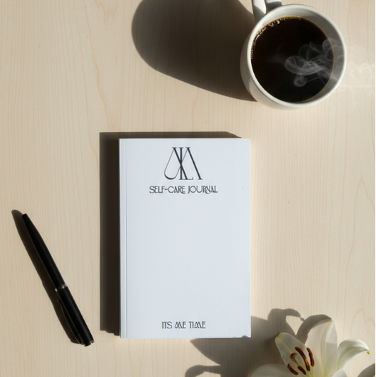 Self-care journal with a pen and coffee cup on a light surface